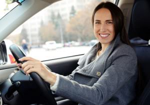 Woman smiling while behind the wheel of a car