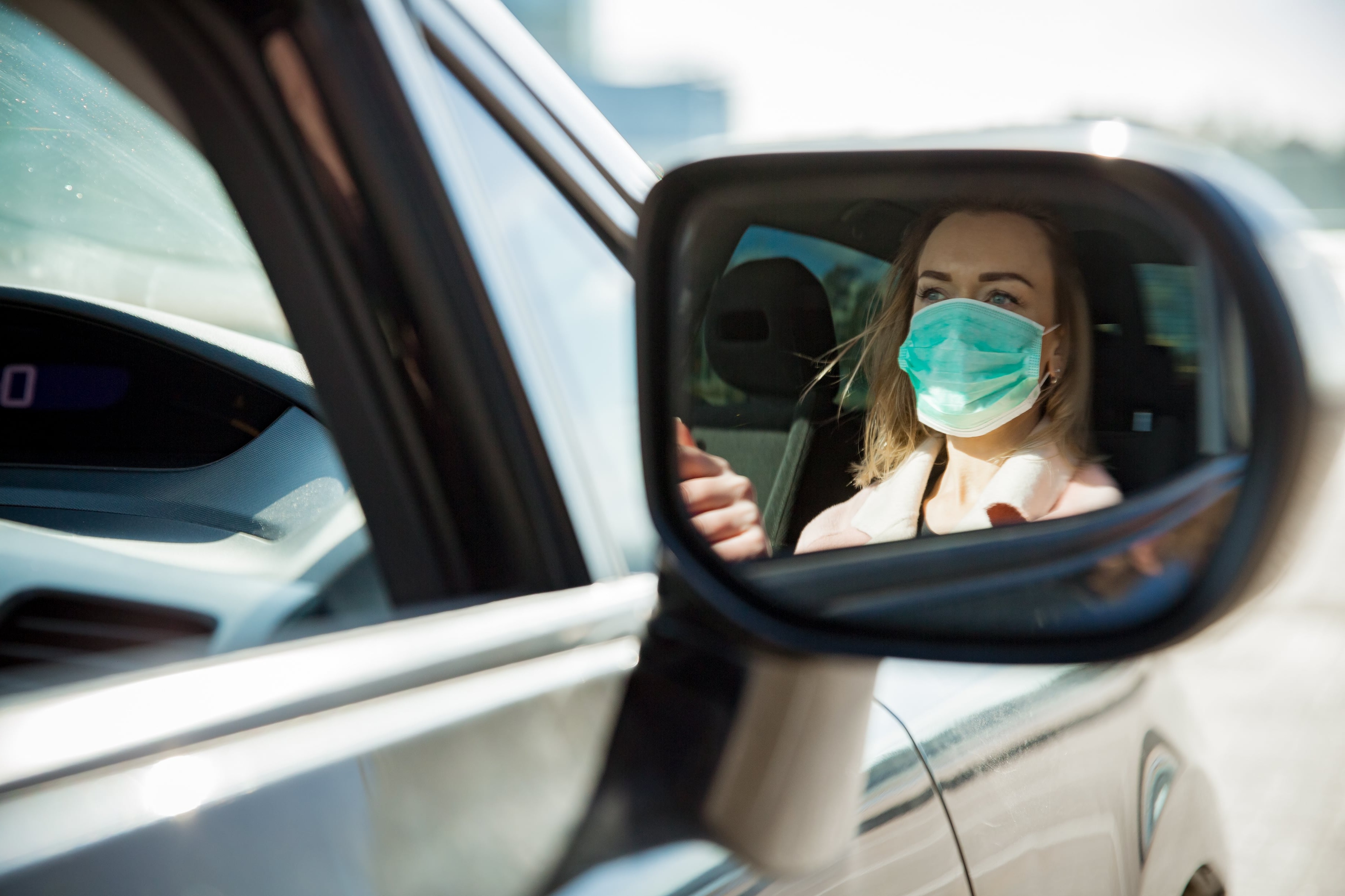 Driver reflection in mirror wearing face mask